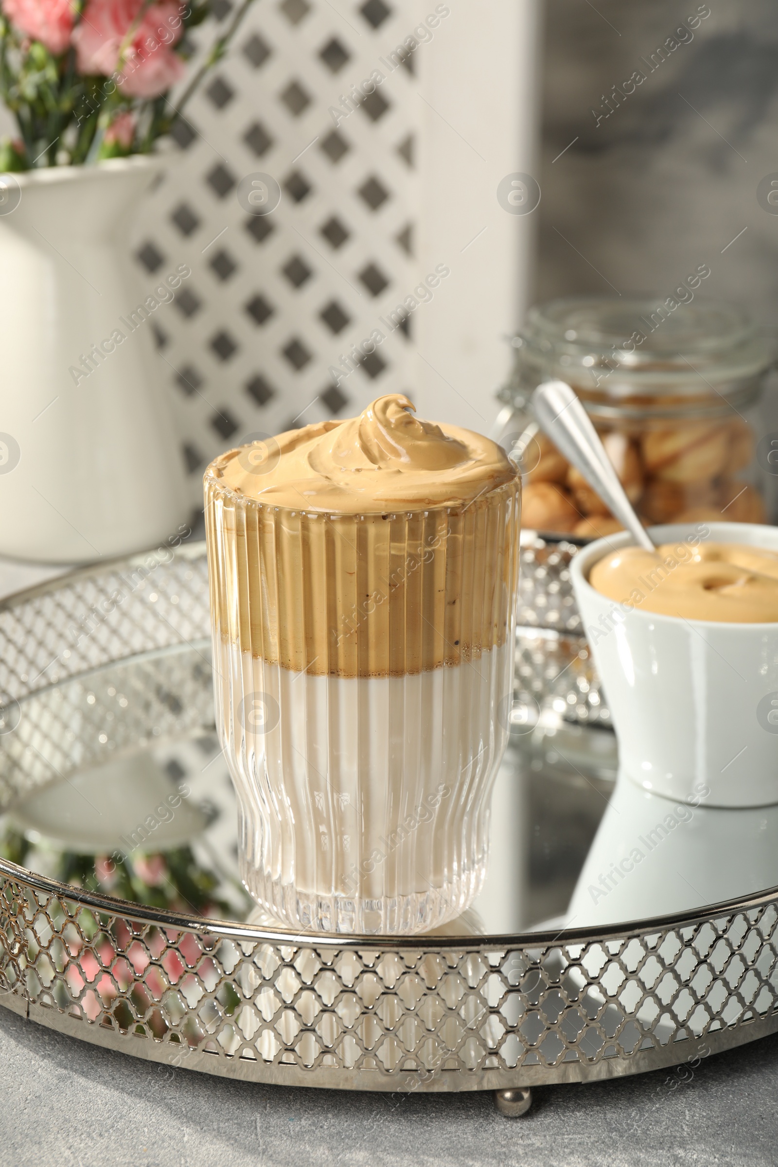 Photo of Glass of delicious dalgona coffee on light grey table