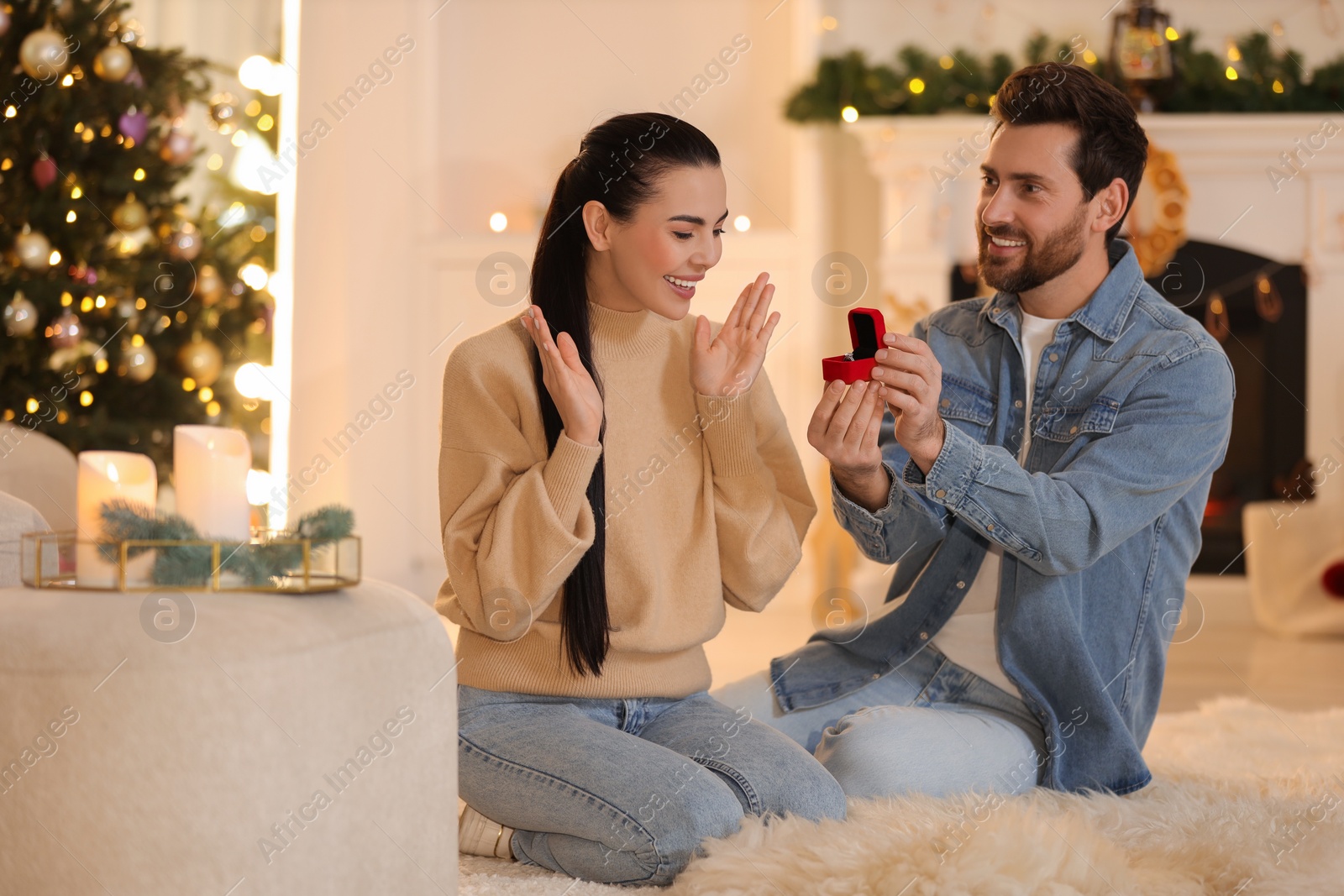 Photo of Man with engagement ring making proposal to his girlfriend at home on Christmas
