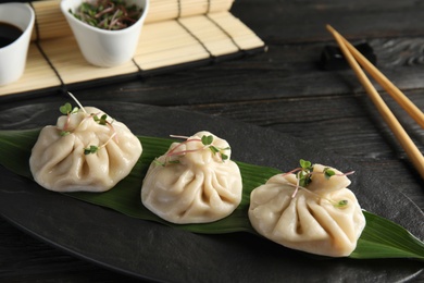 Slate plate with tasty baozi dumplings on table, closeup