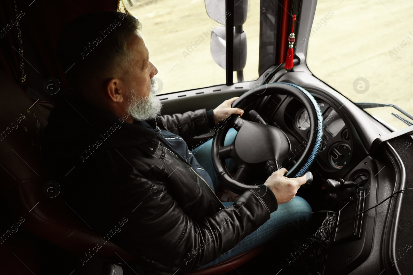 Photo of Mature driver sitting in cab of modern truck