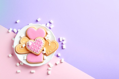 Photo of Composition with decorated heart shaped cookies and space for text on color background, top view