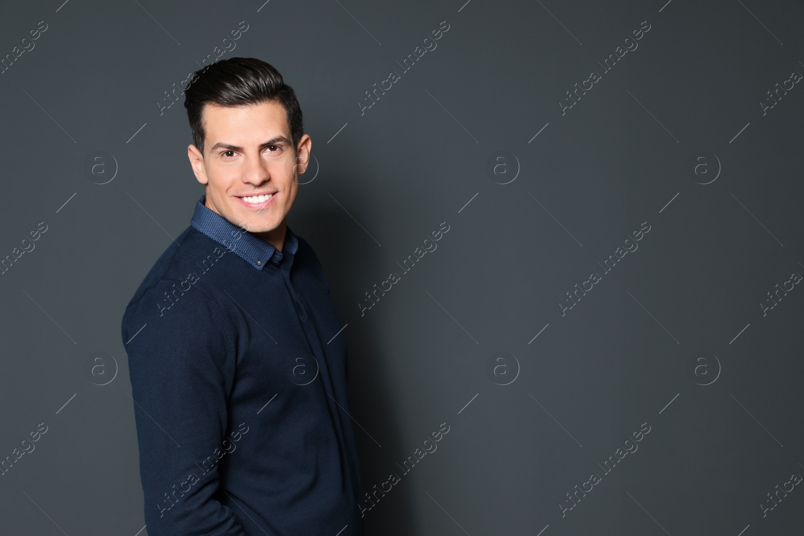 Photo of Portrait of handsome man smiling on grey background. Space for text