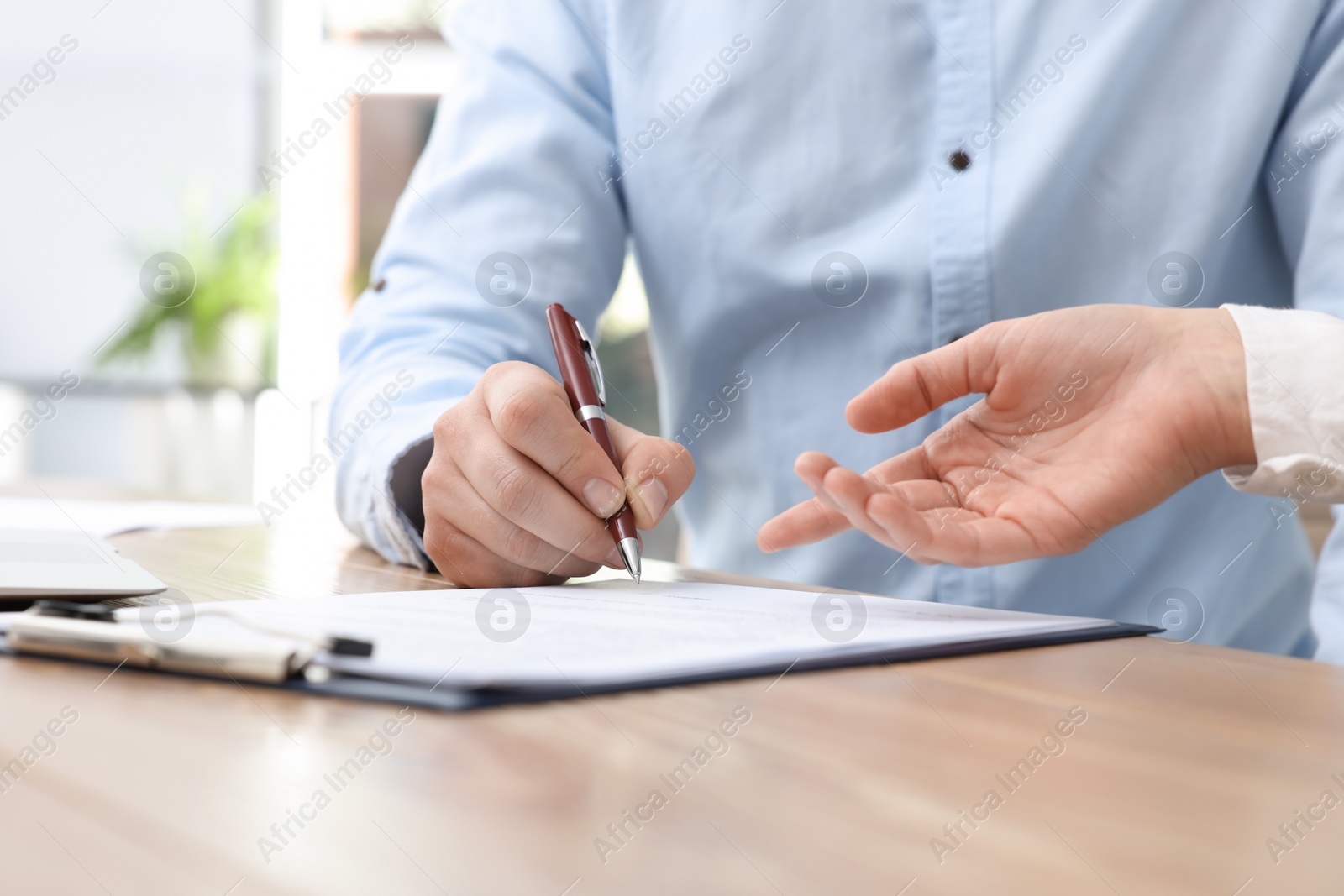 Photo of Businesspeople signing contract at table in office, closeup