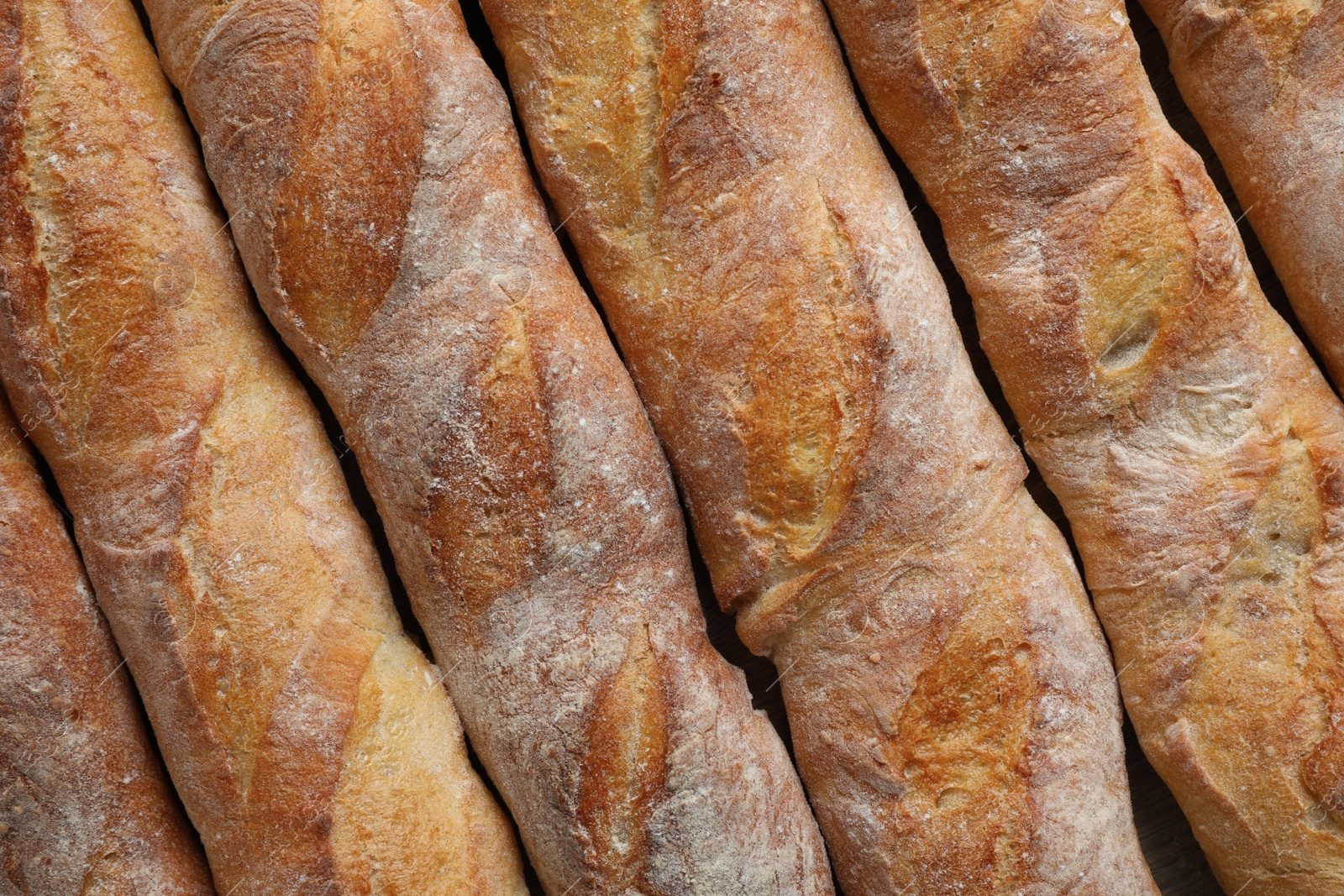 Photo of Crispy French baguettes as background, top view. Fresh bread