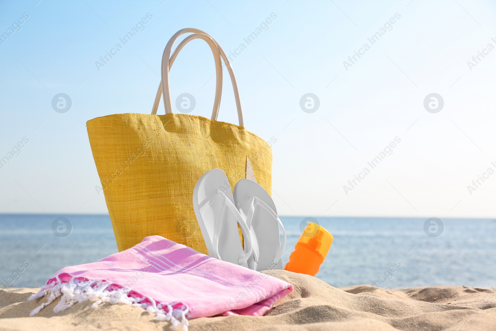 Photo of Beach accessories on sand near sea. Space for text