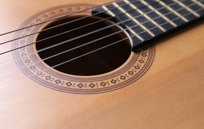 Photo of Closeup view of acoustic guitar, focus on sound hole