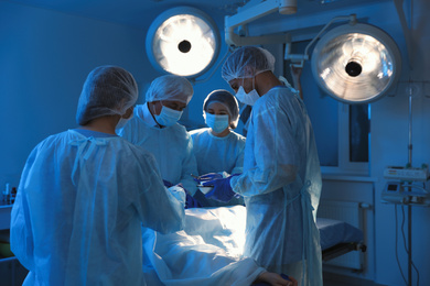 Team of professional doctors performing operation in surgery room