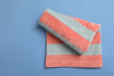 Photo of Striped beach towel on blue background, top view