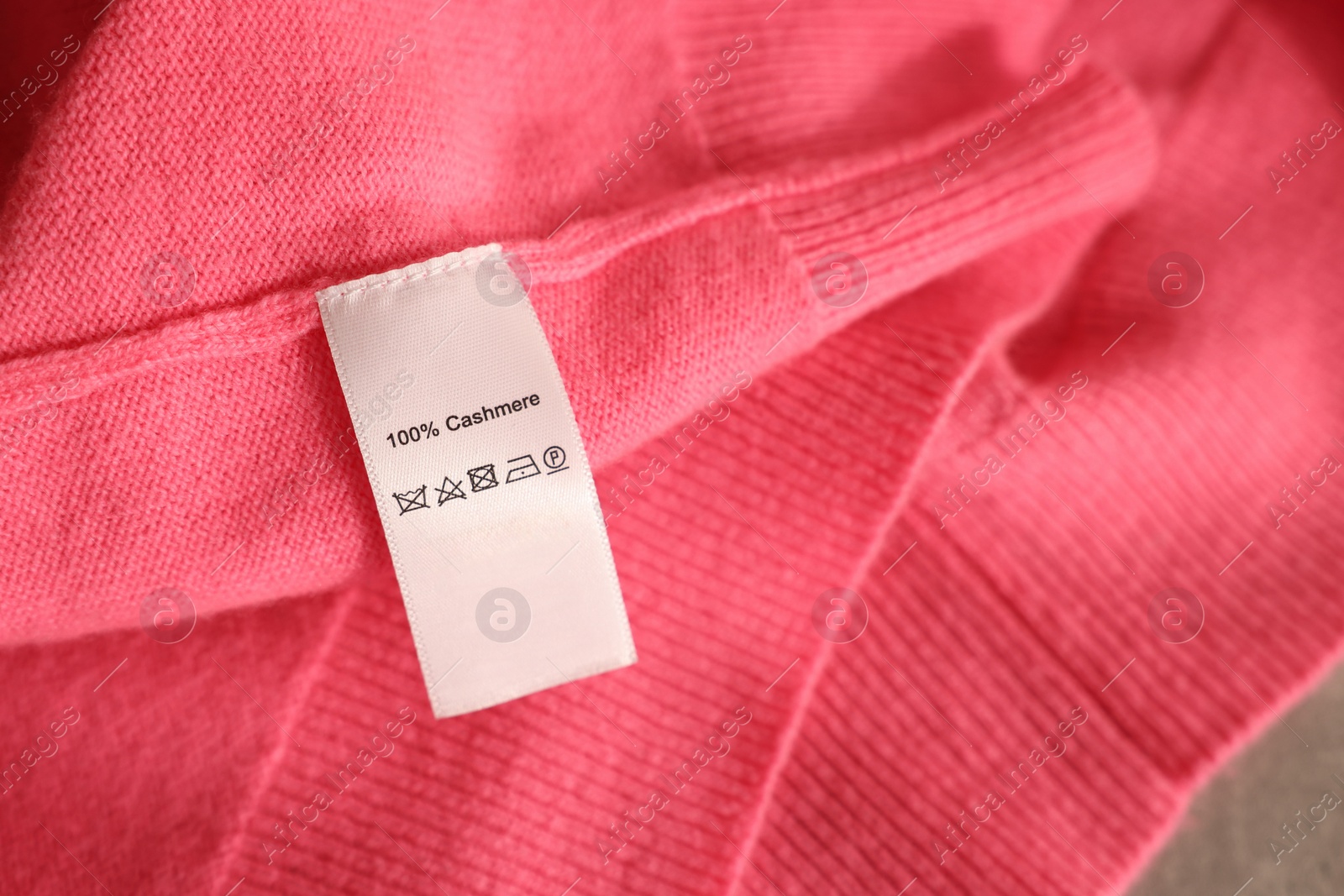 Photo of Clothing label on coral garment, closeup view