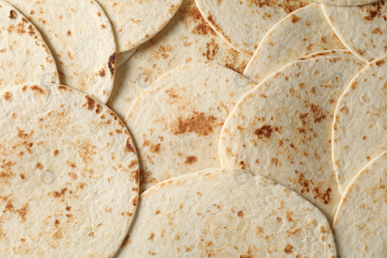 Photo of Many tasty homemade tortillas as background, top view