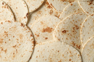 Many tasty homemade tortillas as background, top view
