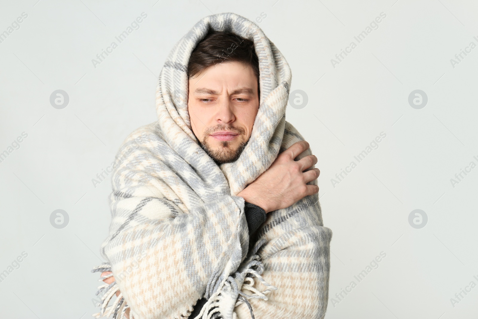 Photo of Man wrapped in blanket suffering from cold on white background