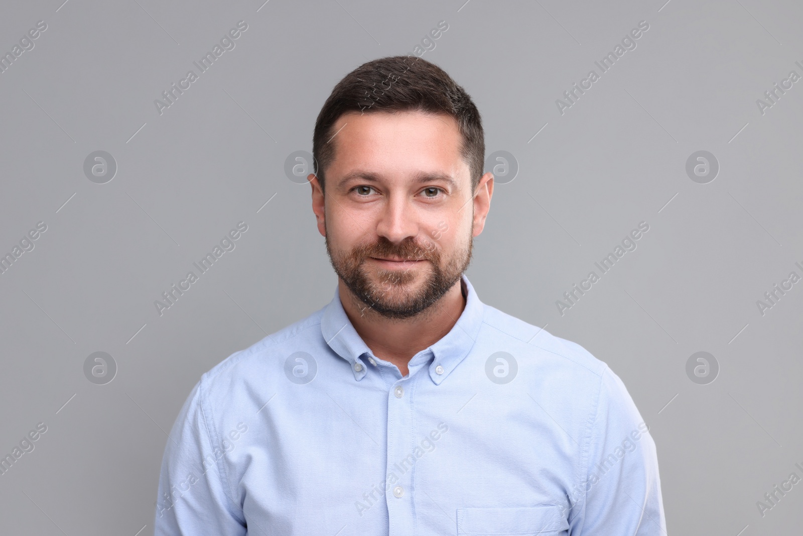 Photo of Portrait of man looking at camera on grey background