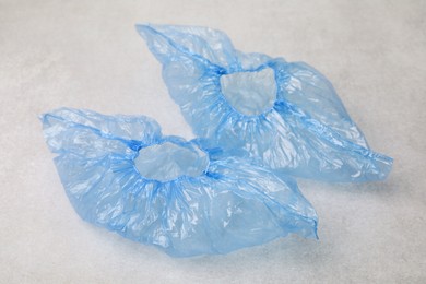 Photo of Pair of blue medical shoe covers on light grey background