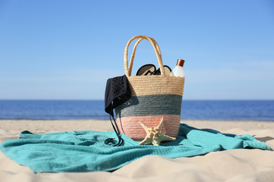 Photo of Stylish beach accessories for summer vacation on sand near sea