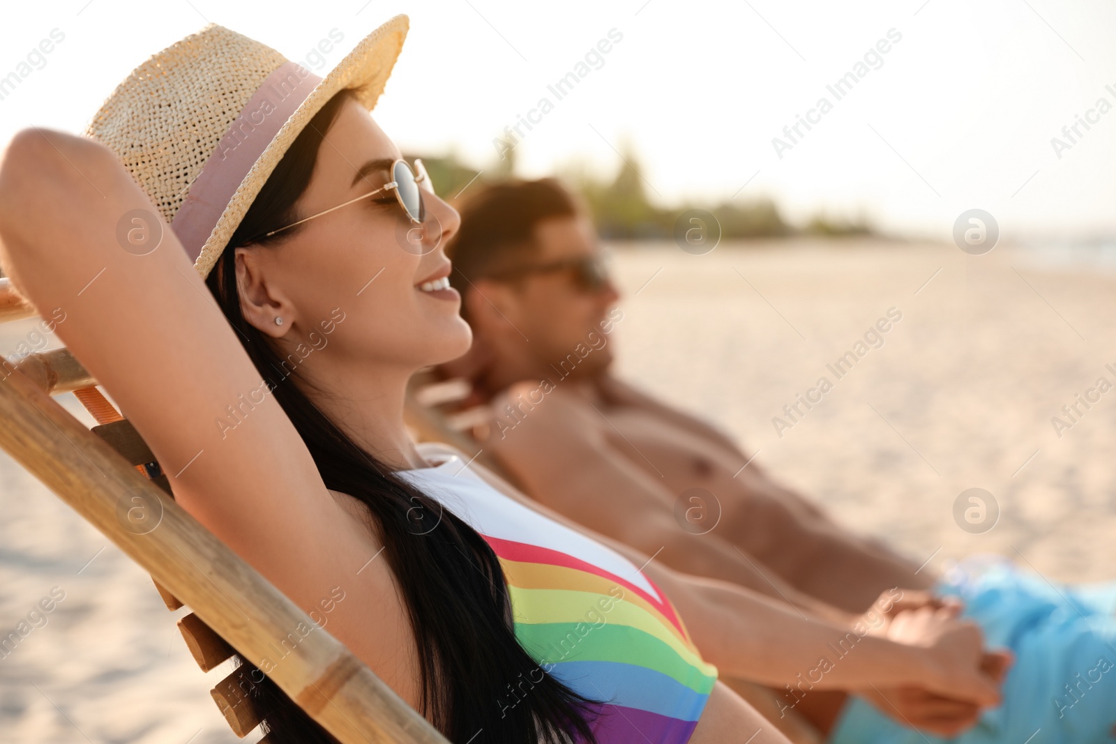 Photo of Couple resting on sunny beach at resort