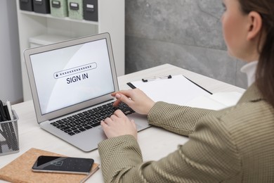 Woman unlocking laptop with blocked screen indoors, closeup