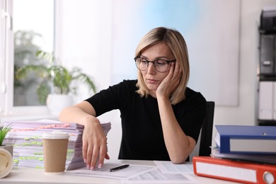 Overwhelmed woman sitting at table in office