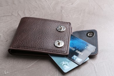 Leather wallet with credit cards on grey textured table, closeup