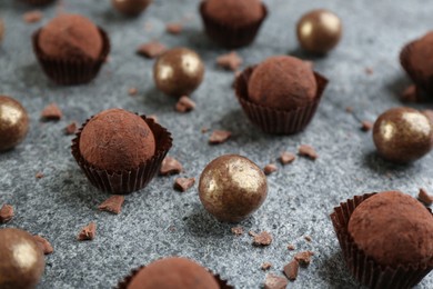 Photo of Different delicious chocolate candies on grey table, closeup