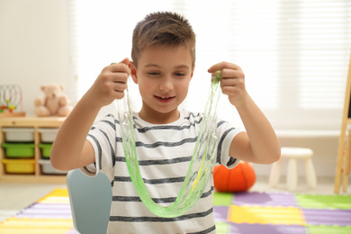 Little boy playing with slime in room