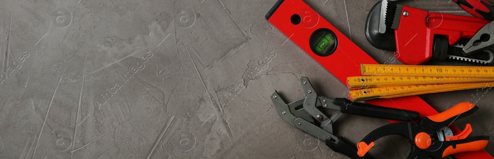 Image of Flat lay composition with repair tools on grey stone table, space for text. Banner design