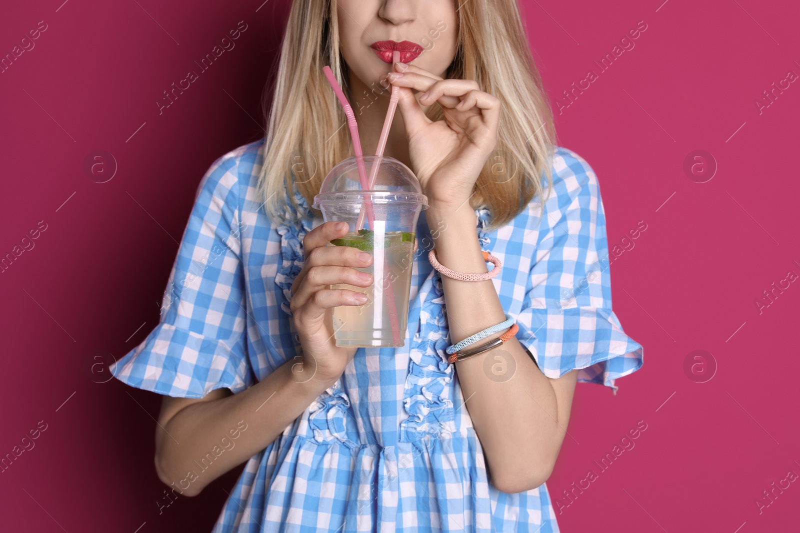 Photo of Young woman with tasty lemonade on color background. Natural detox drink