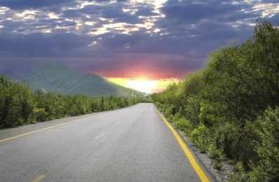 Image of Empty asphalt road, trees and mountain at beautiful sunset