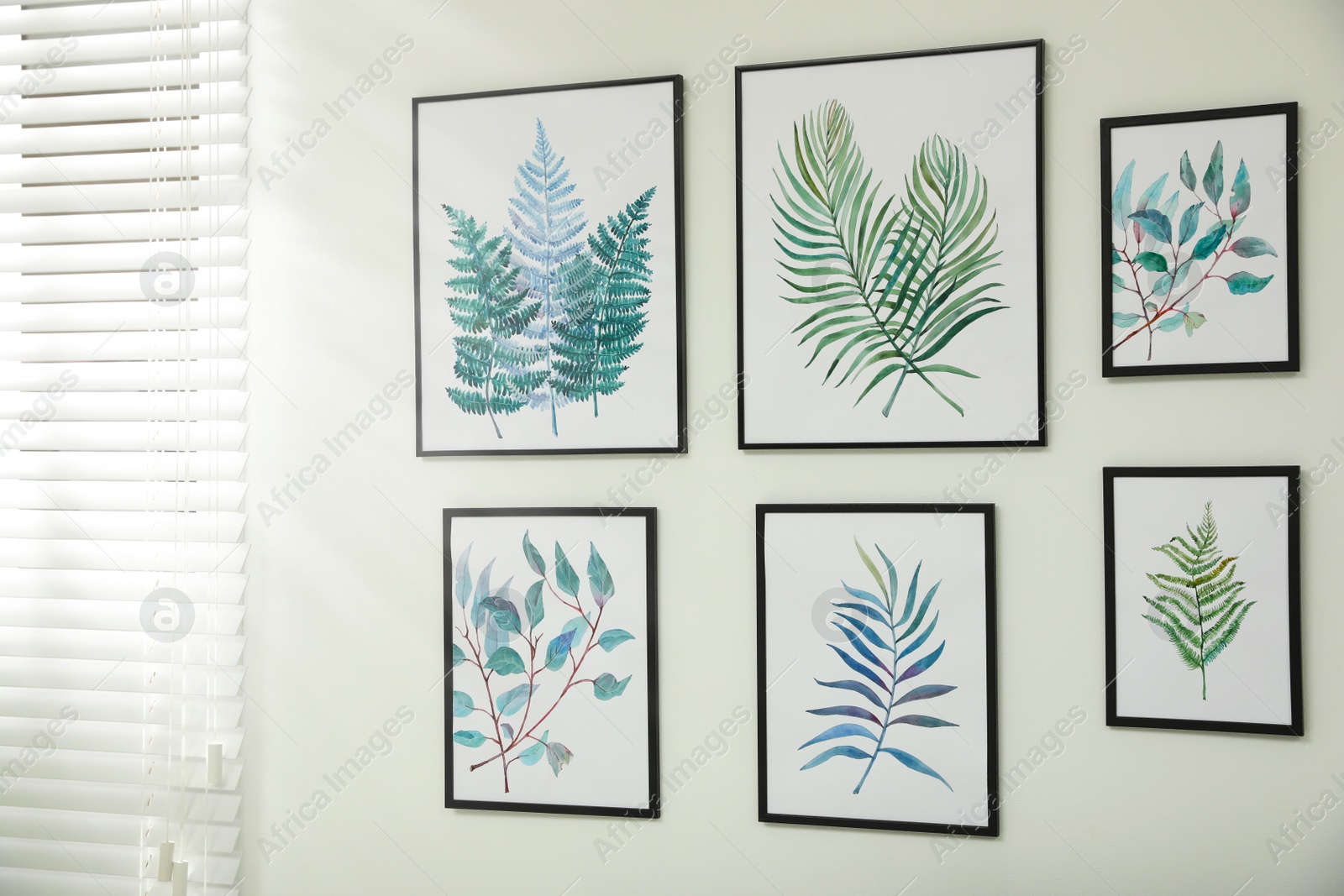 Photo of Beautiful paintings of tropical leaves on white wall in  room