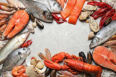 Photo of Fresh fish and different seafood on light grey table, flat lay. Space for text