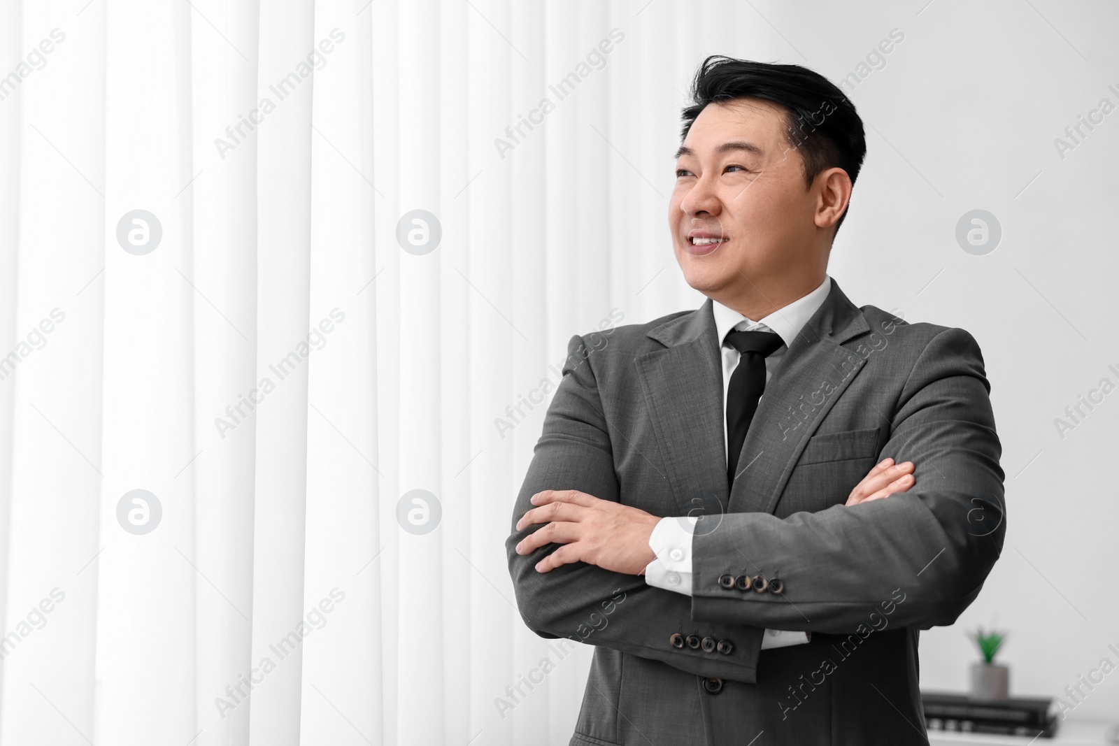 Photo of Portrait of happy notary with crossed arms indoors, space for text