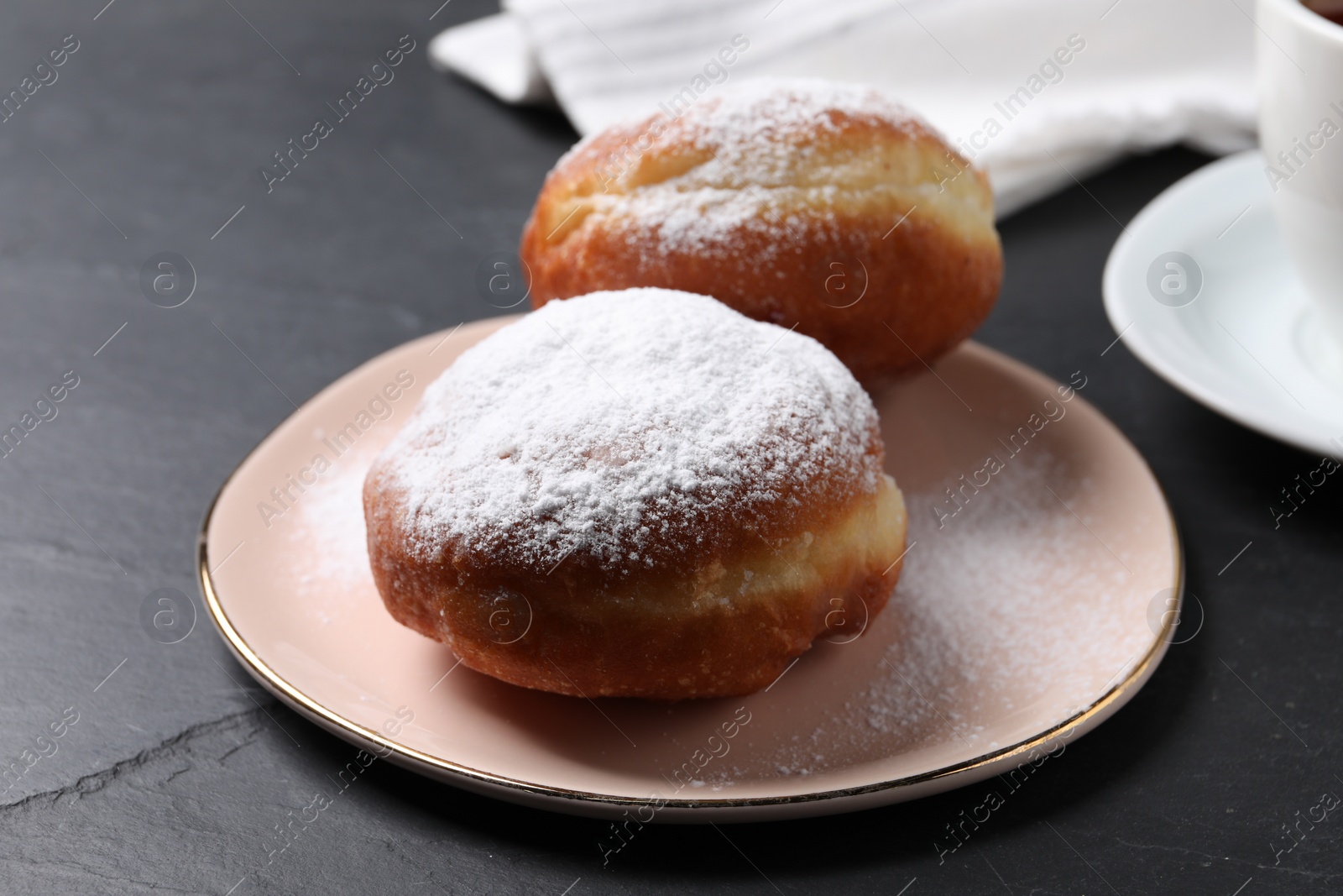 Photo of Delicious sweet buns on dark gray table, closeup