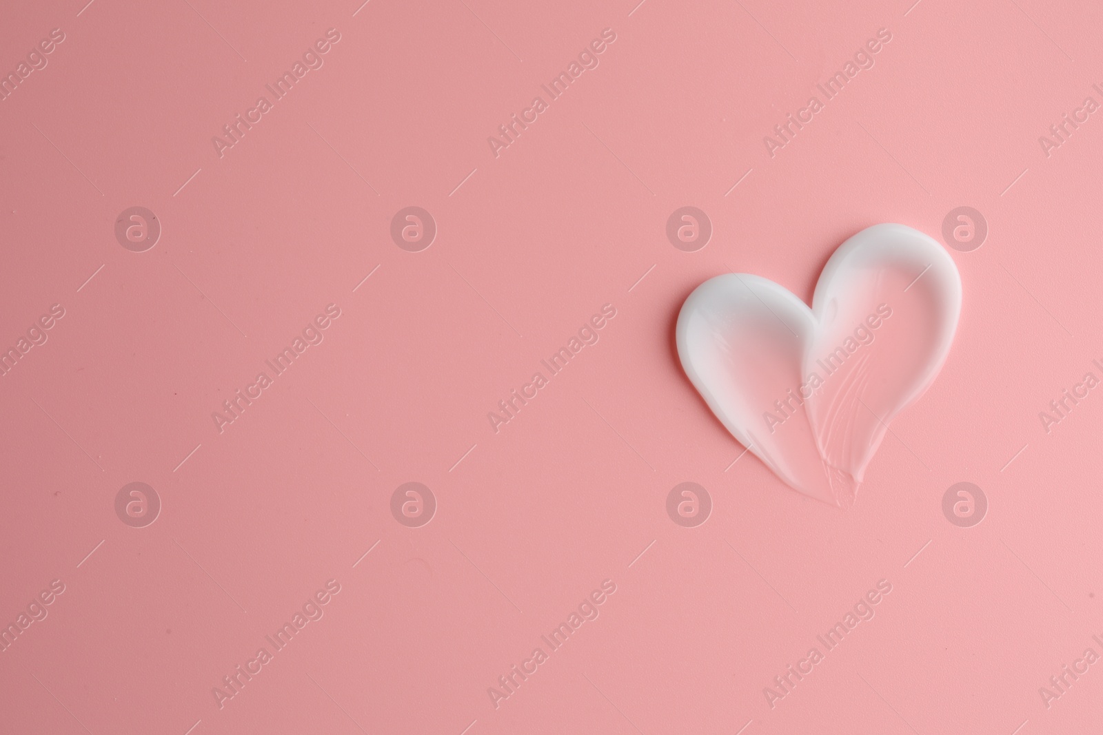 Photo of Sample facial cream on pink background, top view. Space for text