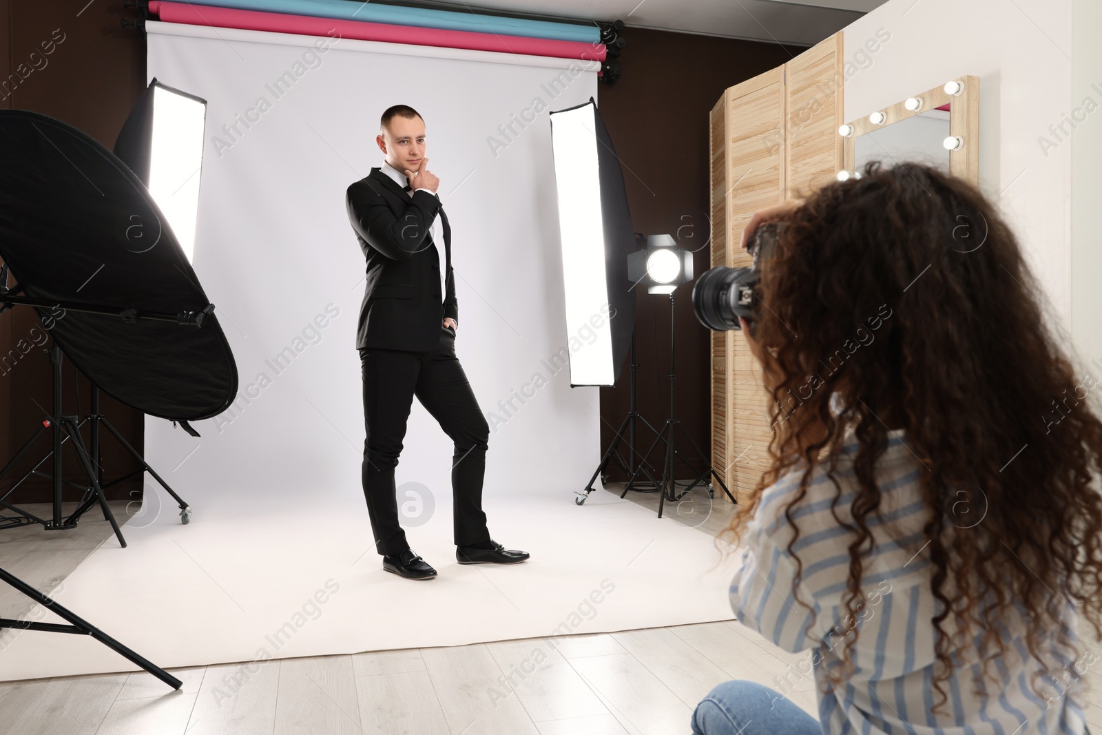 Photo of Handsome model posing for professional photographer in studio