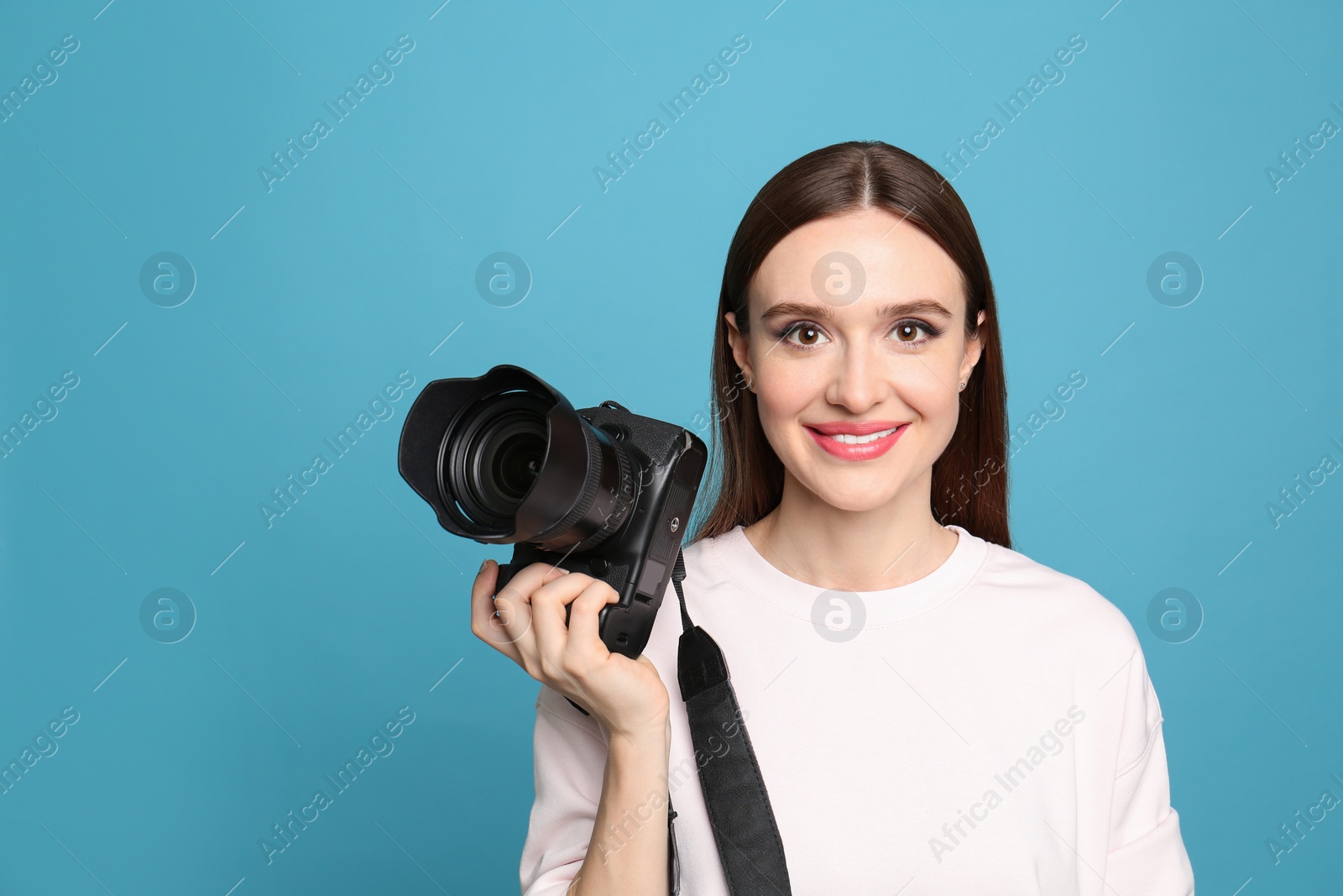 Photo of Professional photographer with modern camera on light blue background