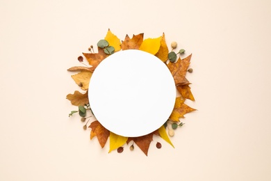 Flat lay composition with autumn leaves and blank card on light background, space for text