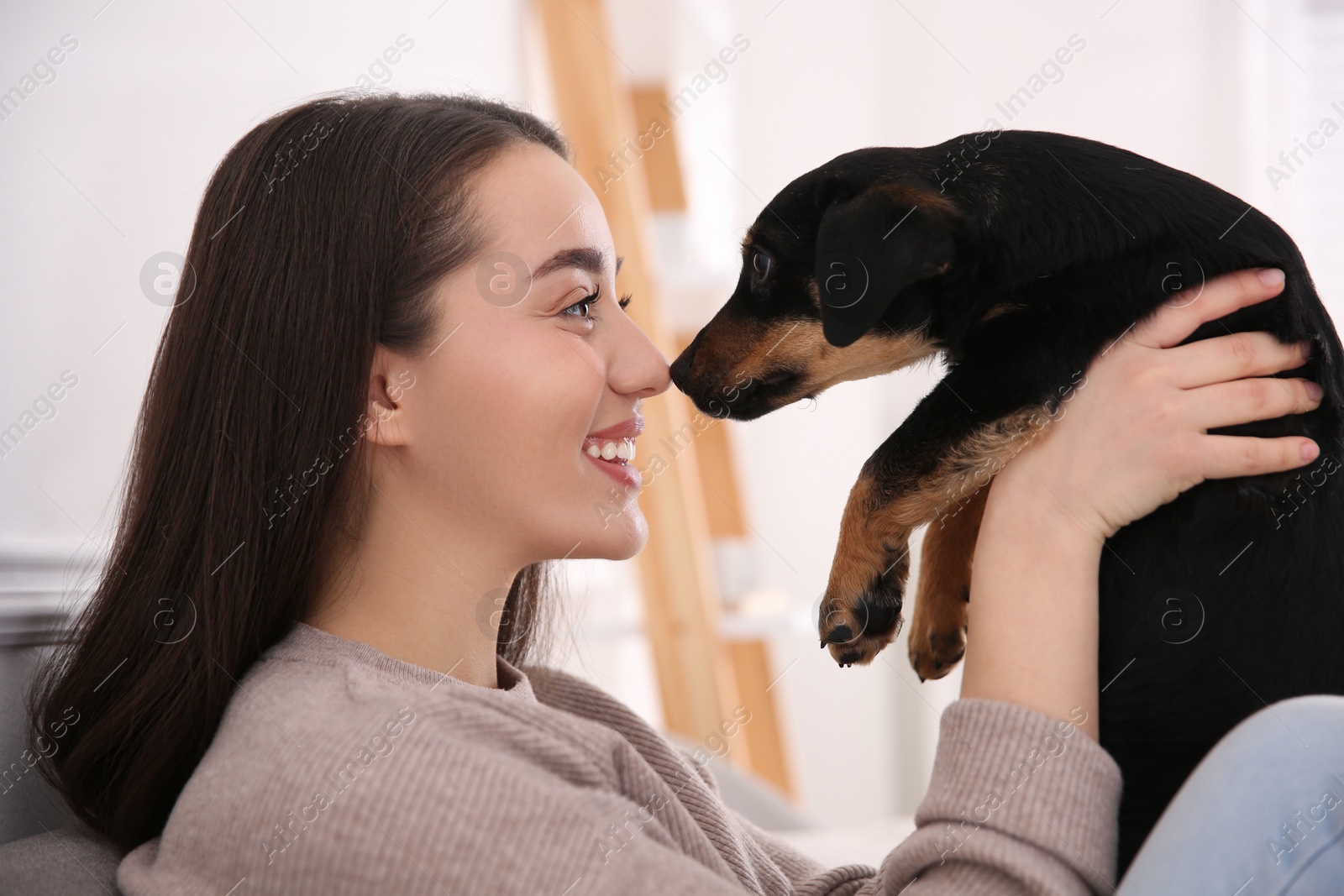 Photo of Woman with cute puppy indoors. Lovely pet