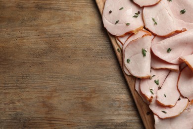 Photo of Delicious sliced ham with thyme and peppercorns on wooden table, top view. Space for text