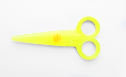 Photo of Colorful plastic scissors on white background. School stationery