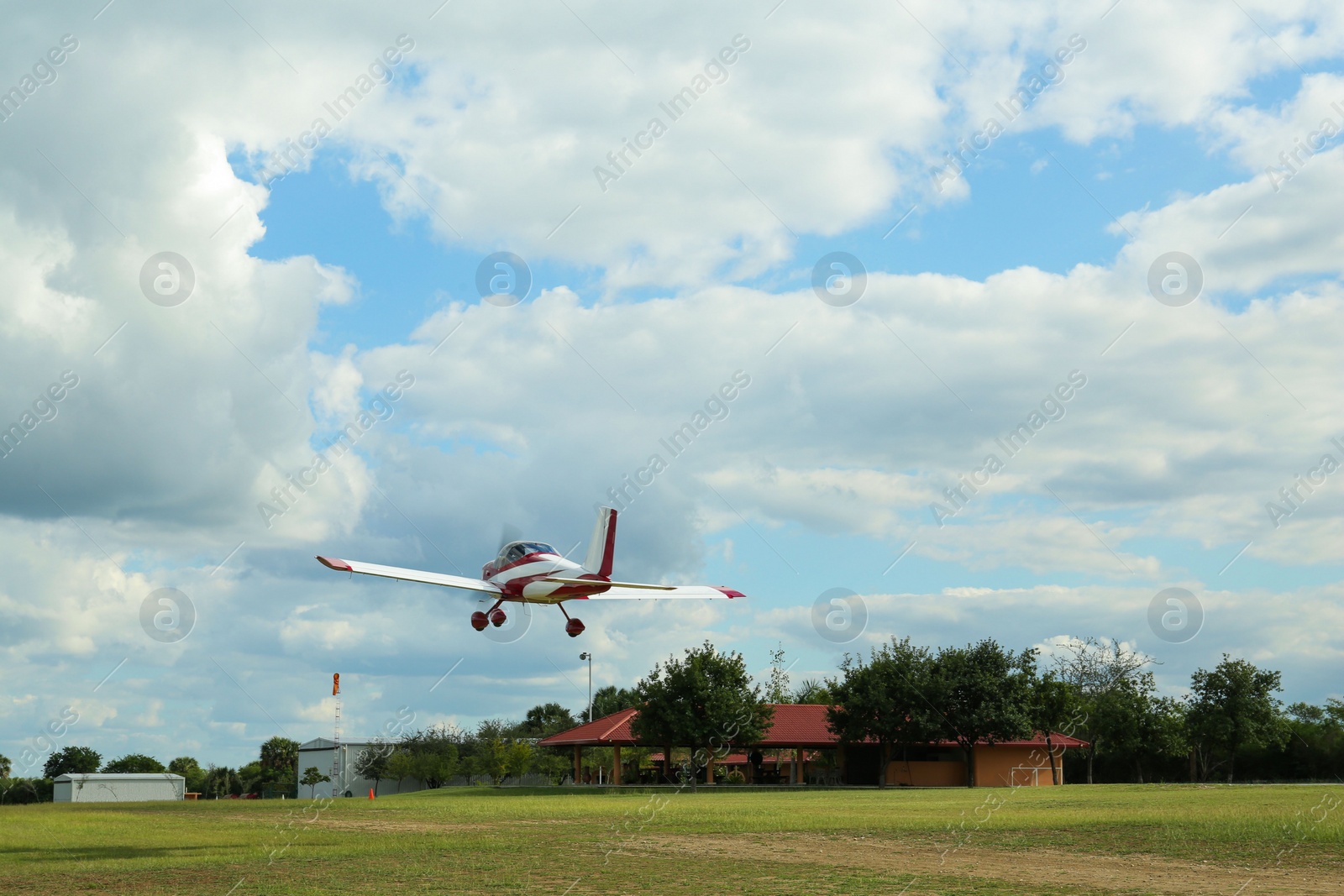 Photo of Modern ultralight airplane flying up from field