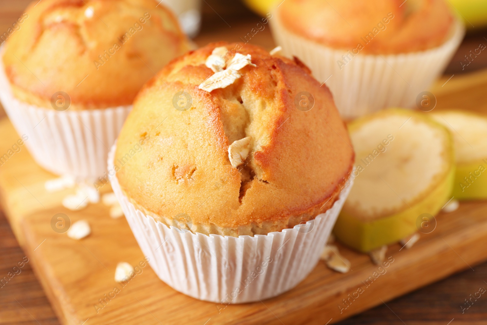 Photo of Tasty muffins served with banana on wooden table, closeup