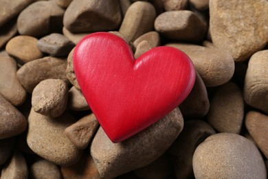 Red decorative heart on stones, top view