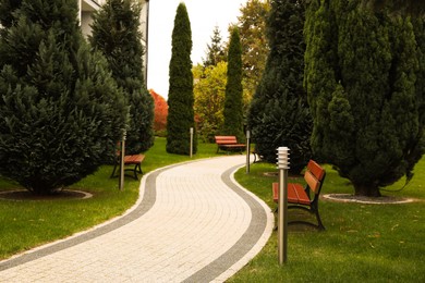 Photo of Winding pathway with beautiful bushes and benches in park