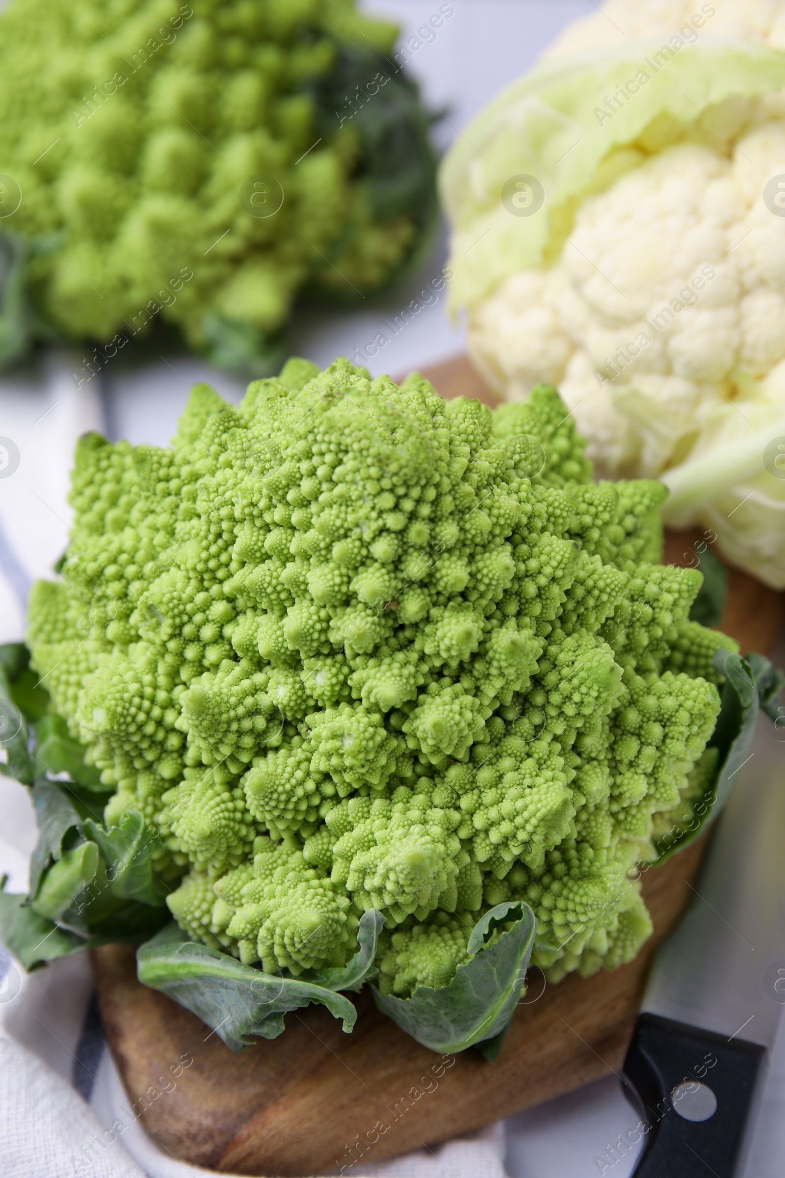 Photo of Fresh Romanesco broccoli and cauliflower on white table, closeup