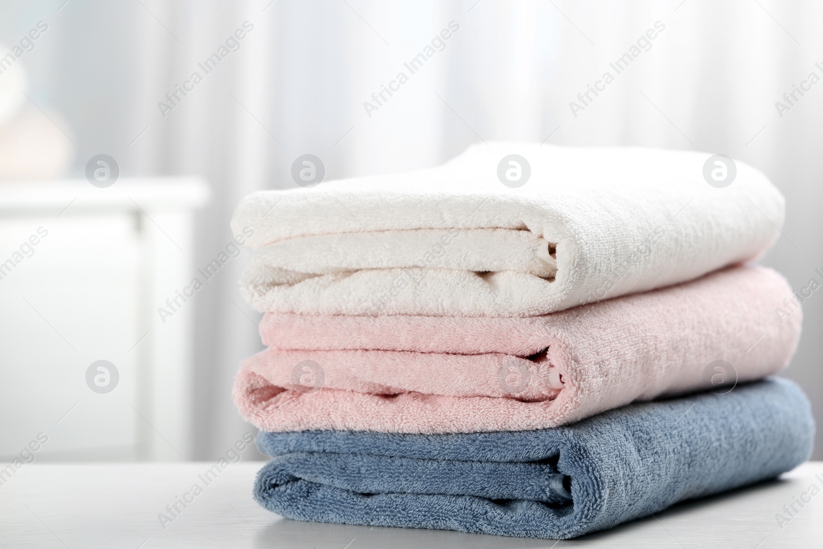 Photo of Stack of fresh soft towels on table