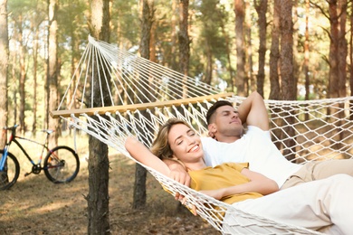 Happy couple resting in hammock outdoors on summer day