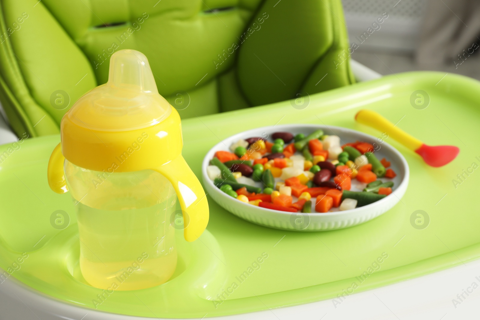 Photo of Baby high chair with healthy food and water, closeup view