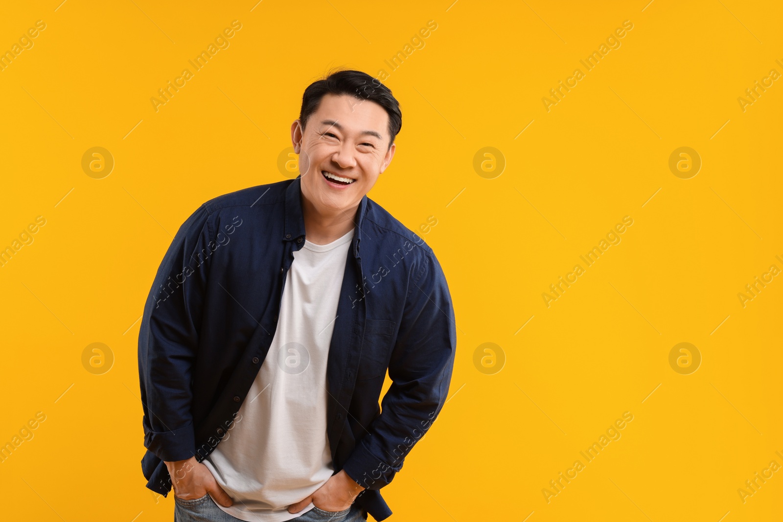 Photo of Portrait of happy man on yellow background. Space for text