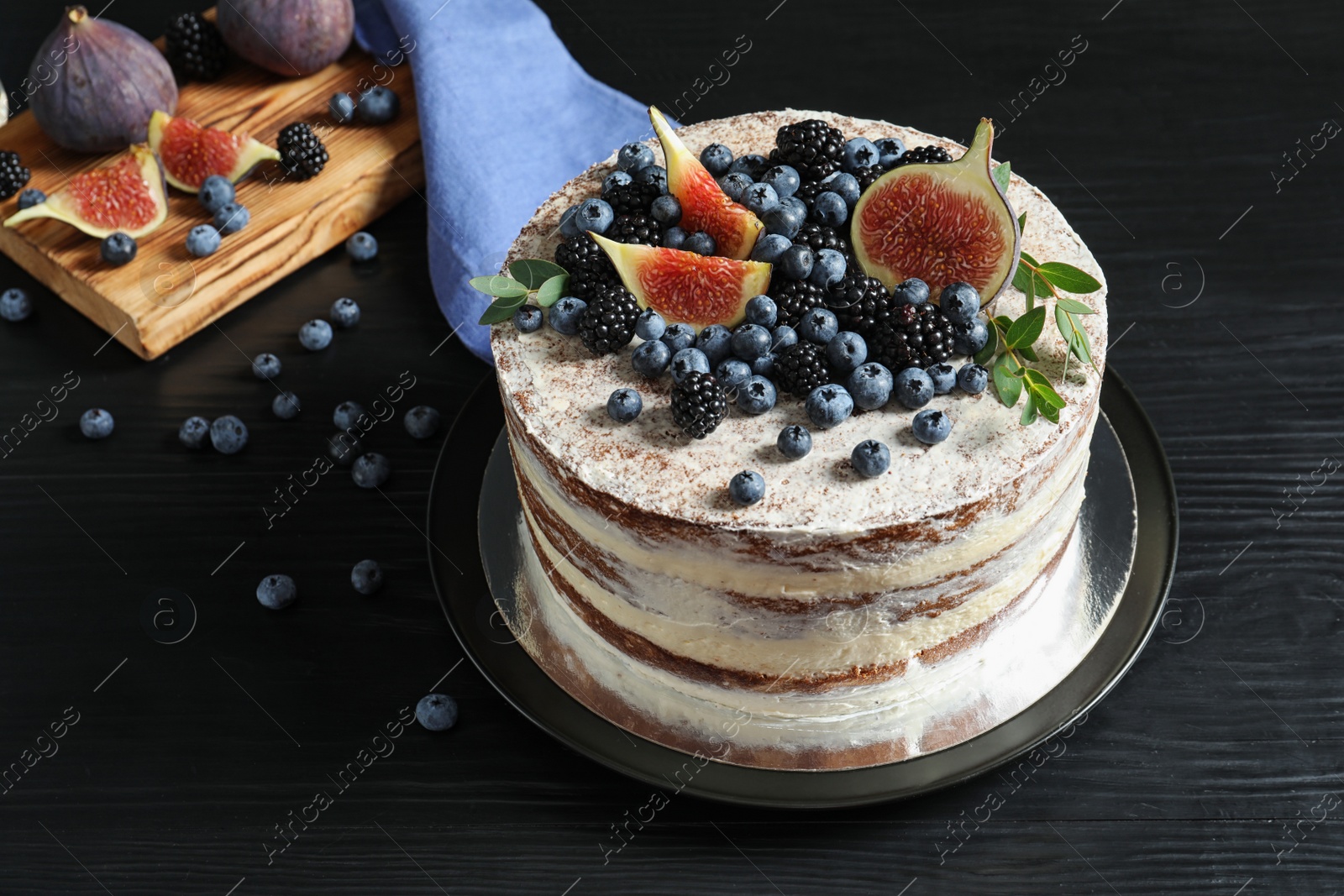 Photo of Delicious homemade cake with fresh berries served on dark wooden table