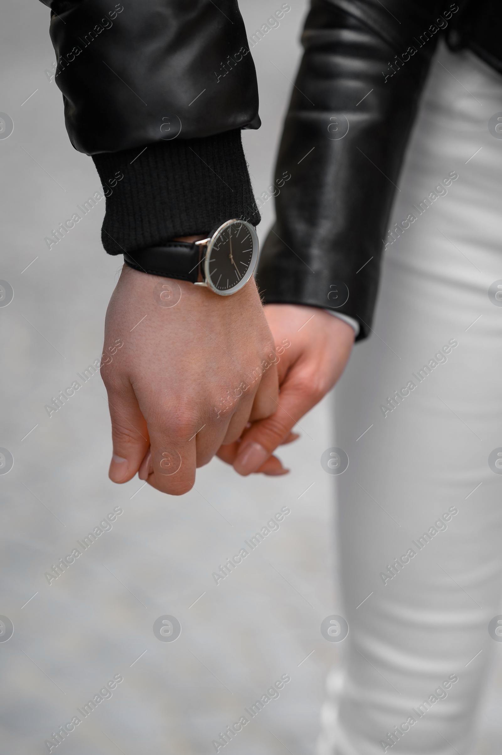 Photo of Lovely couple holding hands together outdoors, closeup. Romantic date